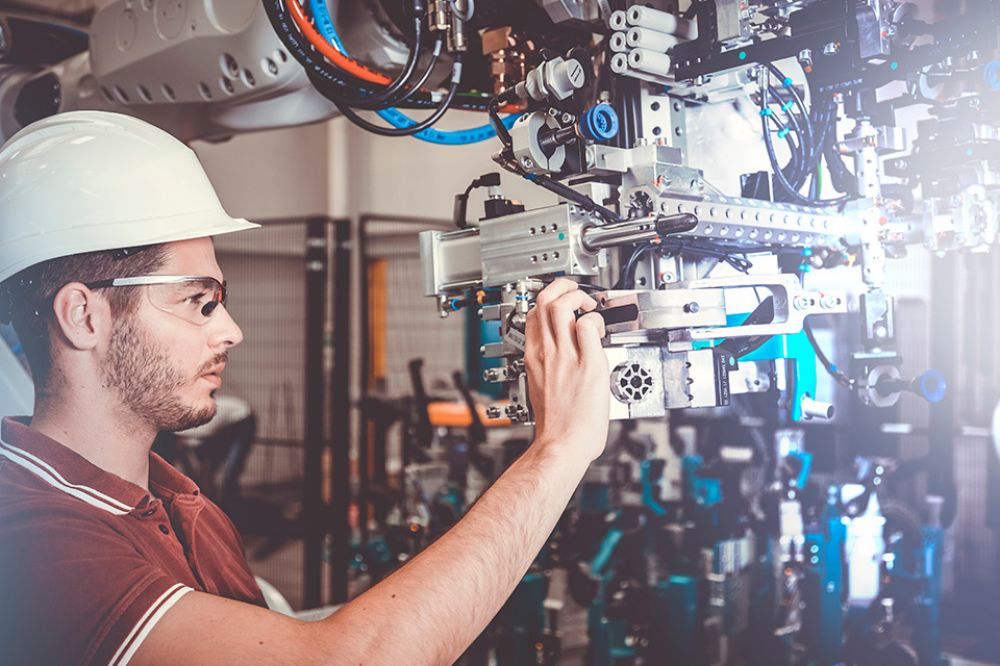 Foto: Mann arbeitet an Maschine